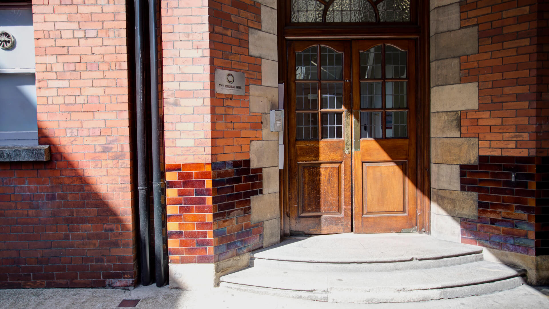 Semi-circular steps lead to the ornate wooden doors of 10-13 Thomas Street