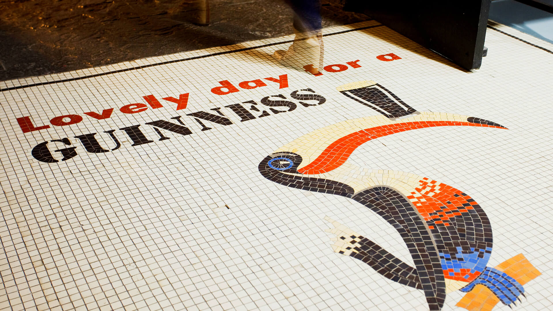 A detailed mosaic floor displaying the famous Guinness Pelican and the text "Lovely day for a Guinness"