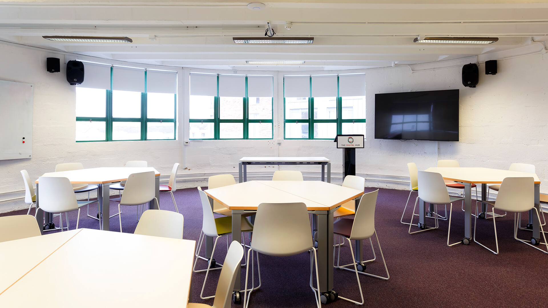 A wide-angle shot of the Learning Studio showing wide windows and hexagonal desks