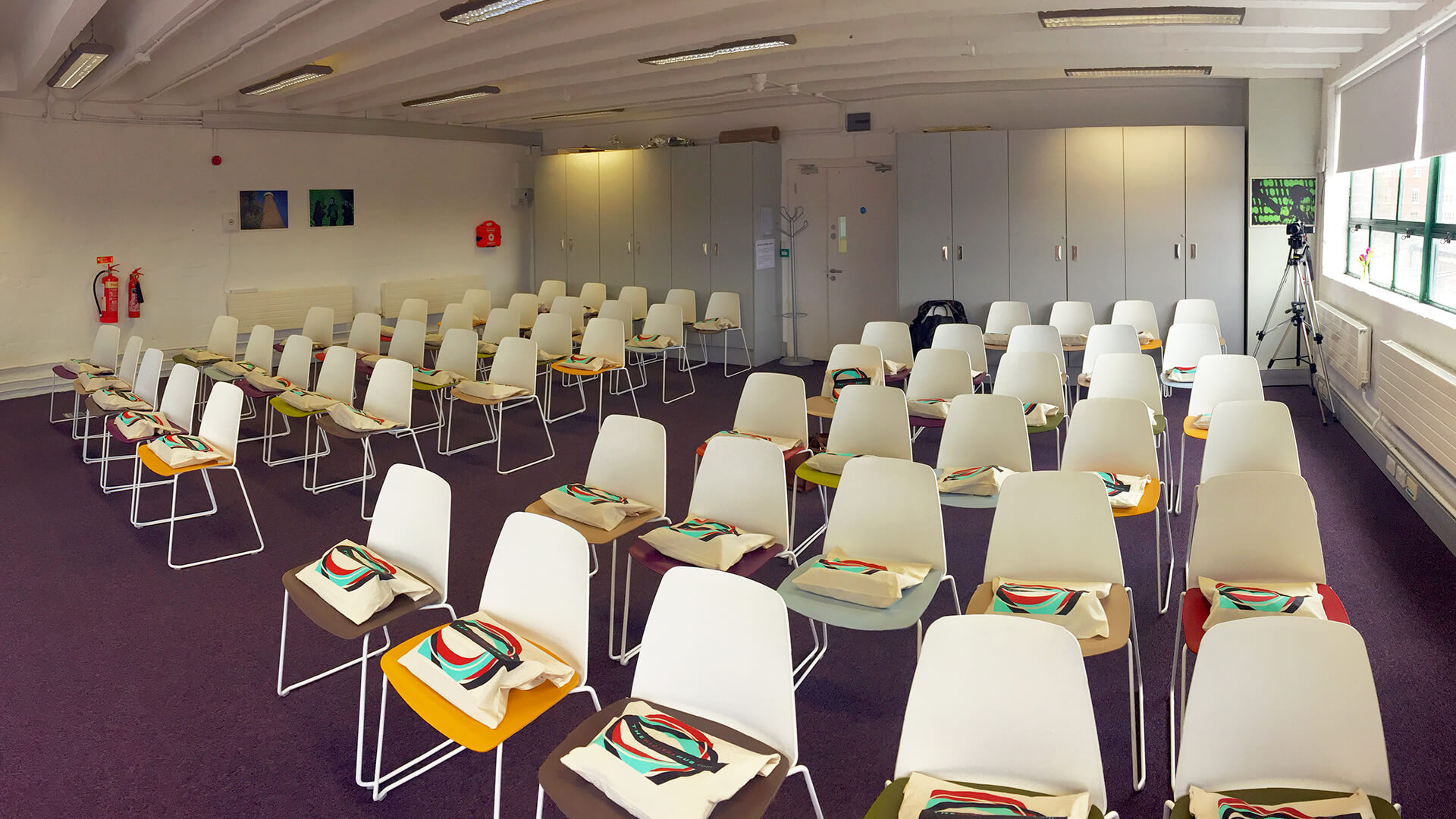 Rows of white chairs in a meeting room with 'Digital Hub' bags on each seat