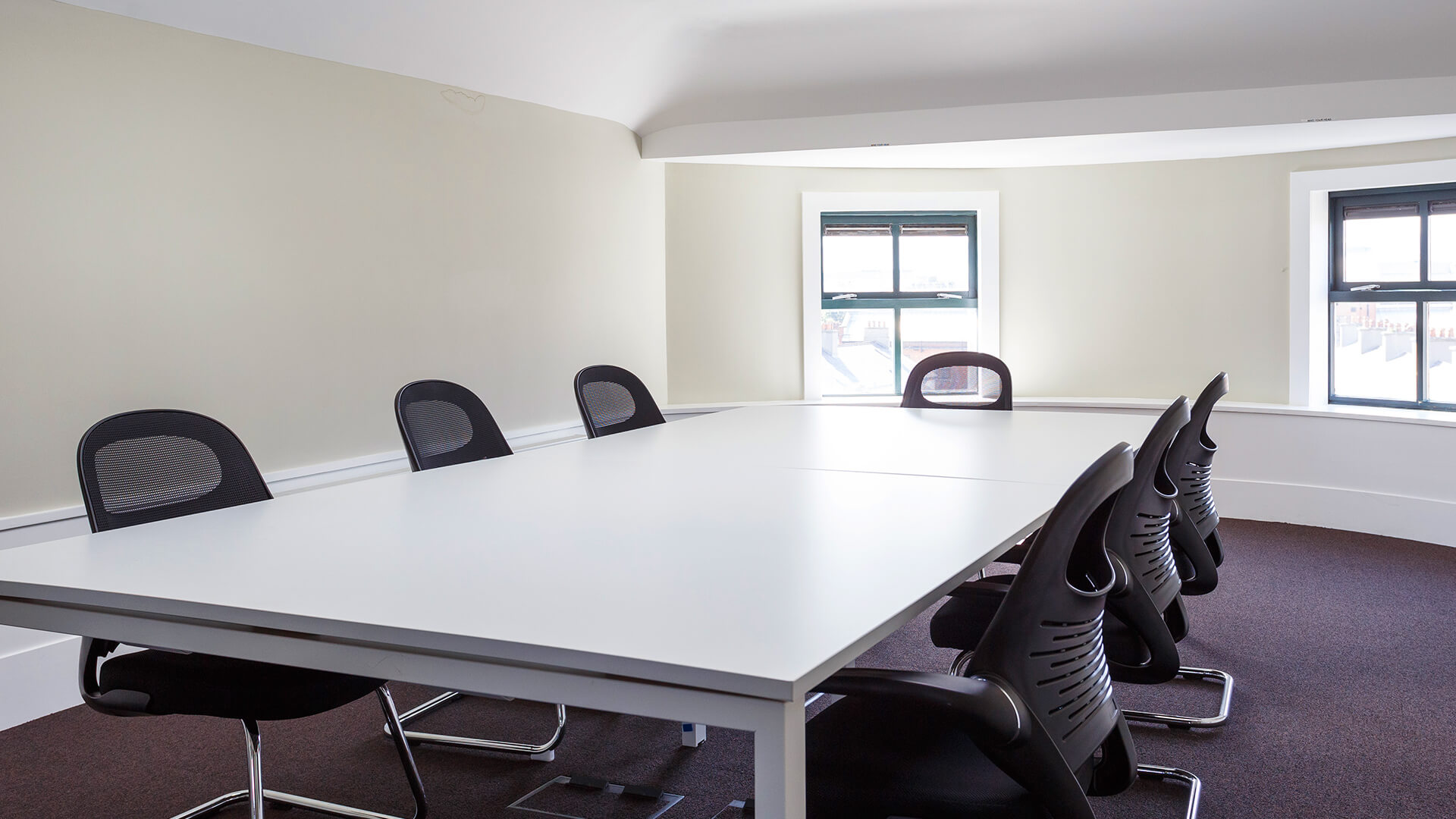 An expansive upstairs meeting room in Townhouse Twenty2 featuring a large table surrounded by modern chairs