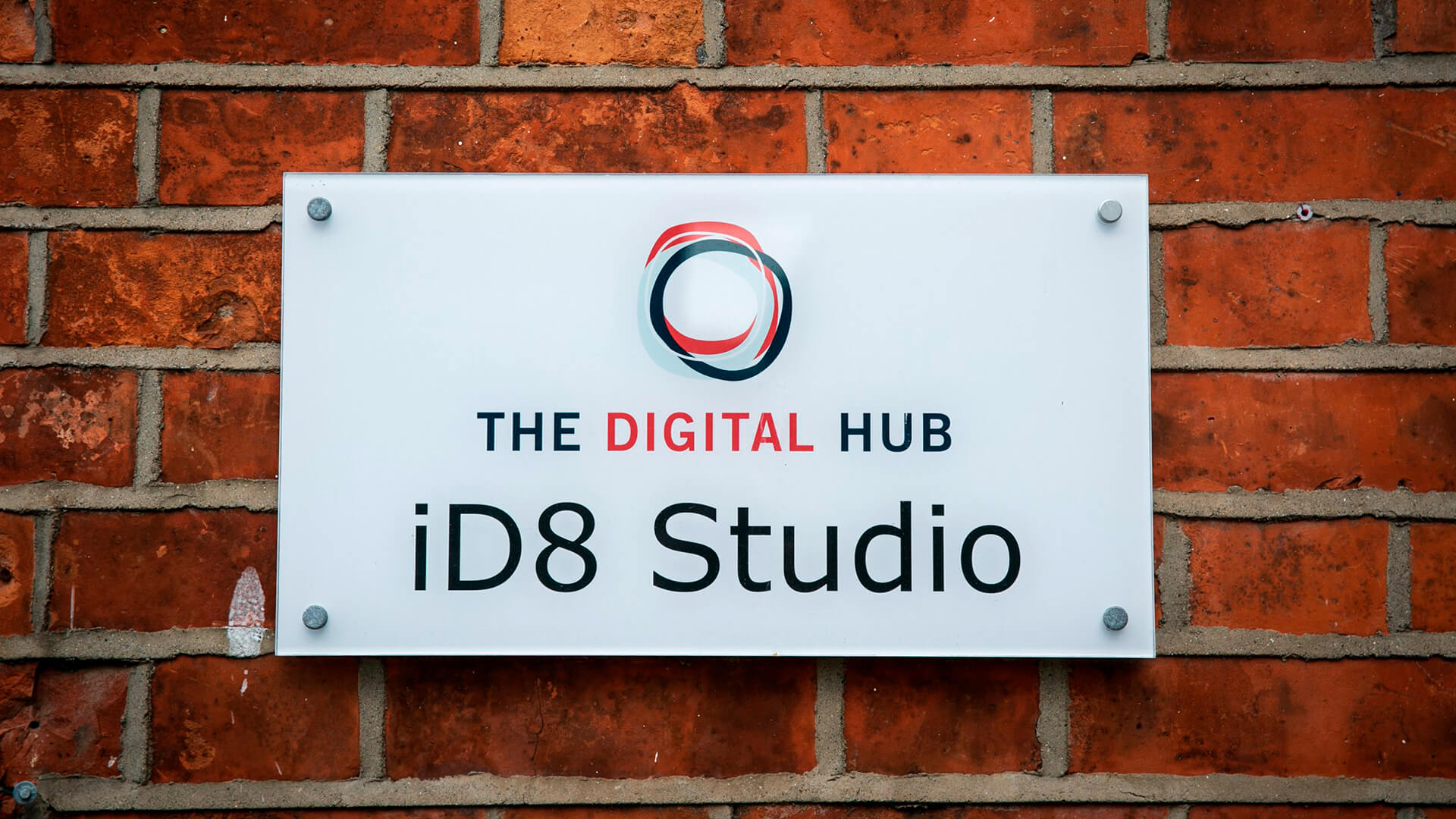 A sign on a brick wall reads: "The Digital Hub iD8 Studio"
