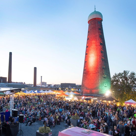 Large crowd at an outdoor event at The Digital Hub with St Patrick's Tower in the background